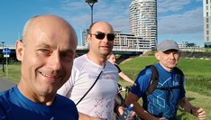 Grupa trzech osób biegnących po mieście 